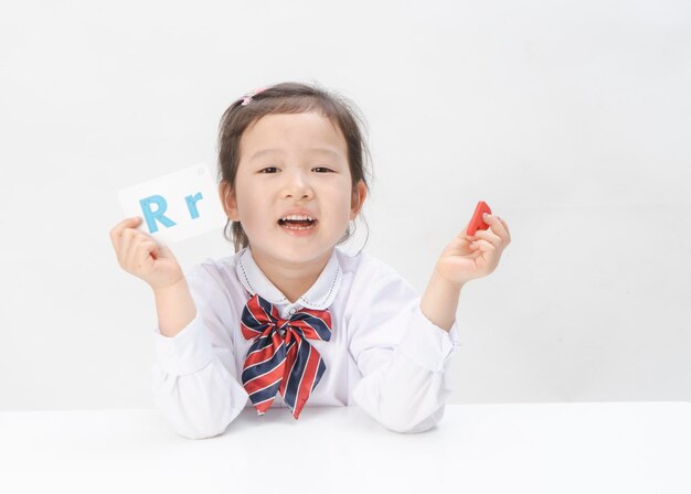 La niña encantadora está aprendiendo letras.