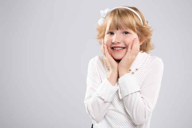 niña encantadora se llevó las manos a las mejillas con felicidad