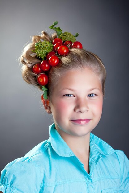 Foto una niña encantadora posando con una corona de tomates