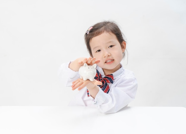 La niña encantadora tiene una alcancía en la mano.