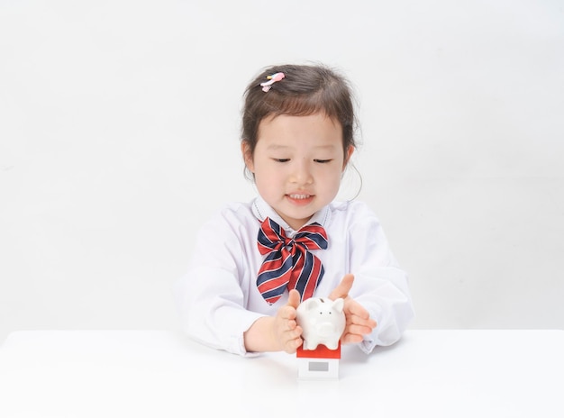 La niña encantadora tiene una pequeña casa en la mano.