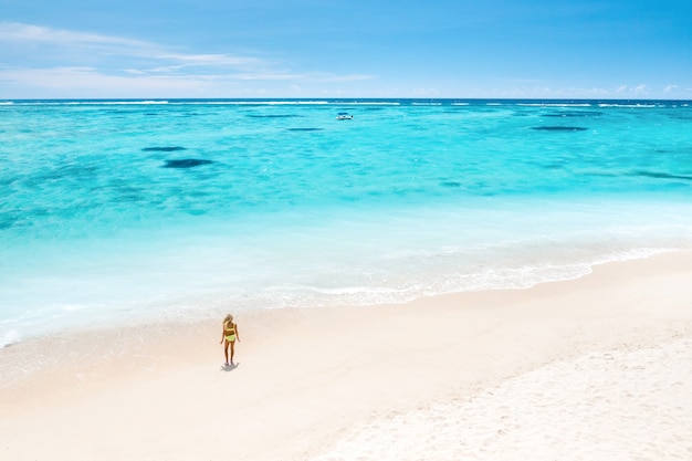 Una niña se encuentra en la playa de Le Morne en el Océano Índico en la isla de Mauricio.