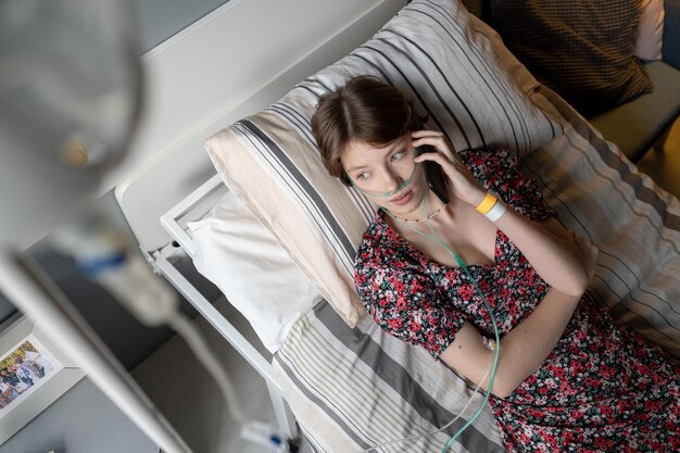 Niña enferma hablando por teléfono en la sala