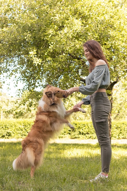 Foto niña enseña a perro a servir