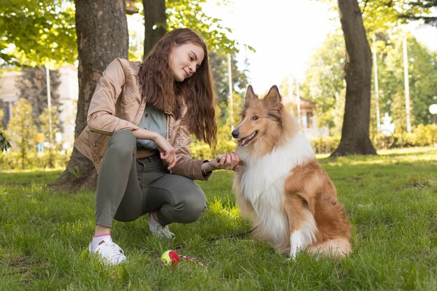 Niña enseña a su perro a dar pata