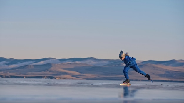 La niña entrena en patinaje de velocidad sobre hielo el niño patina en el  invierno con ropa deportiva azul, gafas deportivas, deporte de patinaje de velocidad  para niños | Foto Premium