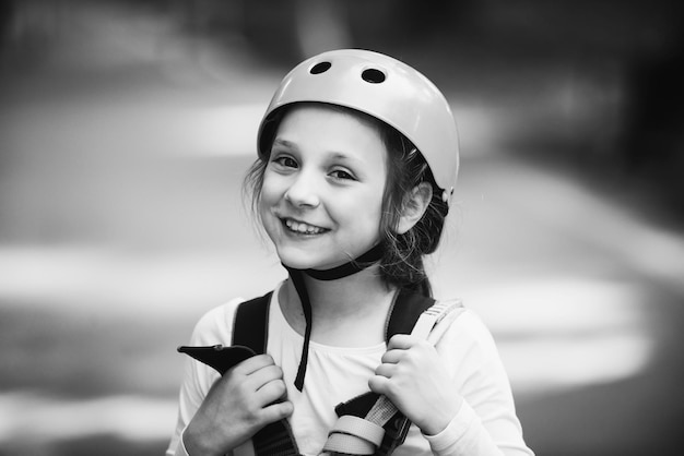 Niña escalando en el parque de actividades de aventura con casco y equipo de seguridad Niña escalando en...