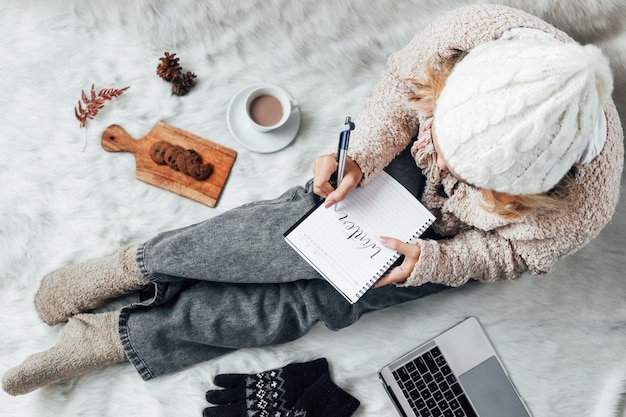 Una niña escribiendo palabras de invierno en un cuaderno para el fondo del concepto de invierno