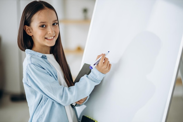 Niña escribiendo en pizarra