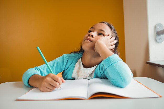 Foto niña escribiendo en su cuaderno