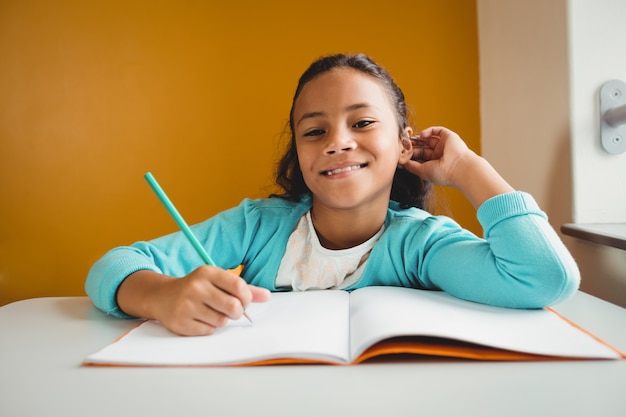 Foto niña escribiendo en su cuaderno