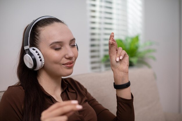 Foto niña escucha música en auriculares con los ojos cerrados