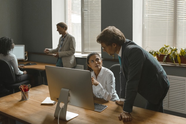 La niña escucha a su supervisor que le da nuevos escenarios. Los empleados trabajan duro en el equipo para