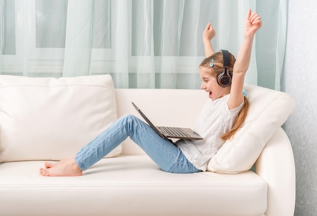 Niña escuchando algo con auriculares