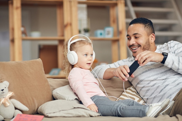 Niña escuchando música con papá