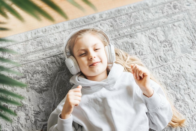 Niña escuchando música tirada en el suelo