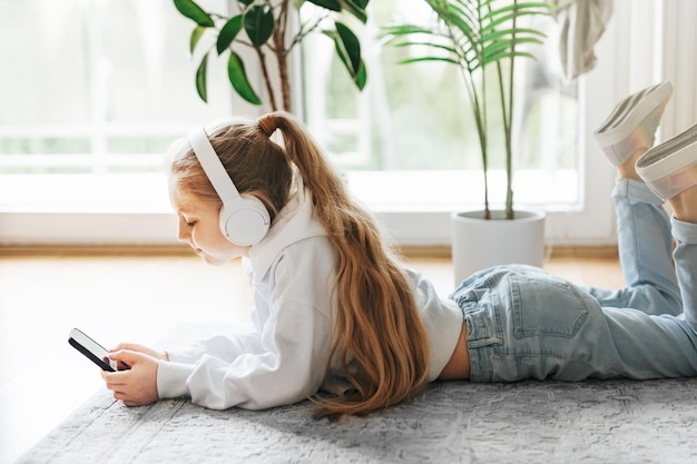 Niña escuchando música tirada en el suelo