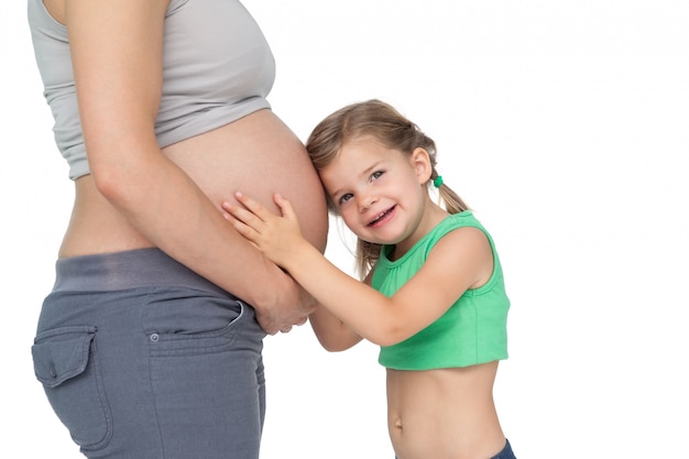 Niña escuchando topetón del bebé de su madre