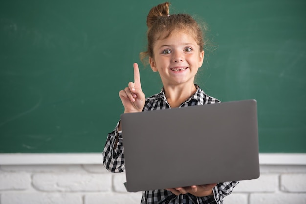 Niña de la escuela aprende la lección sentada en el escritorio estudiando el aprendizaje electrónico en línea usa internet Educación y conocimiento concepto de tecnología moderna