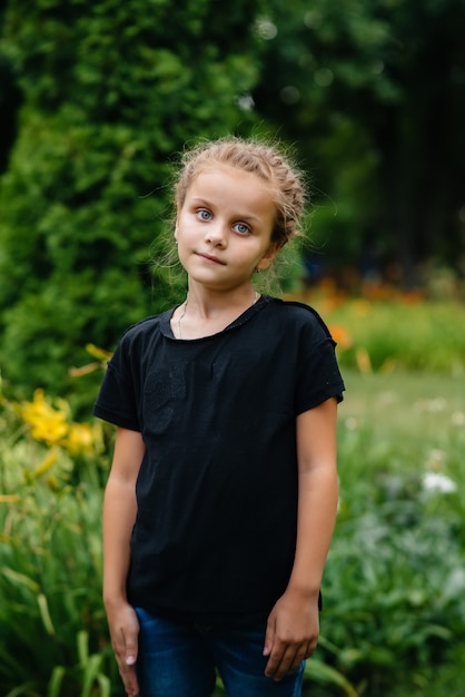 Una niña de la escuela se encuentra y sonríe en un parque al aire libre