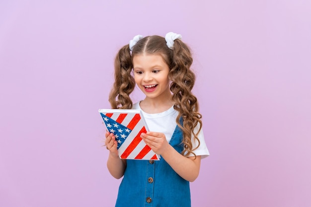 Una niña de la escuela está leyendo un libro de texto de inglés. Mudarse a los EE. UU. para obtener una educación estadounidense.