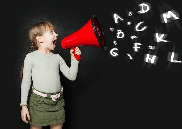 Niña de escuela gritando a través de un concepto de educación de megáfono