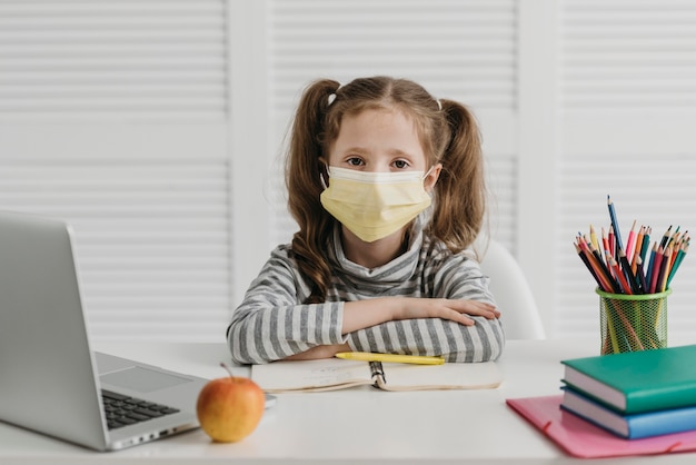 Niña de la escuela con máscara médica vista frontal