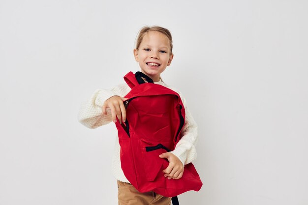 Niña escuela mochila roja posando fondo aislado