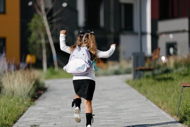 una niña va a la escuela por el parque a lo largo del camino. concepto de educación a distancia. Chica de escuela