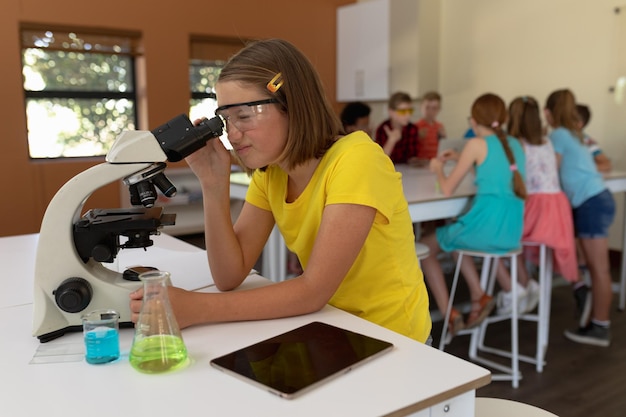 Foto niña de escuela primaria en clase de química