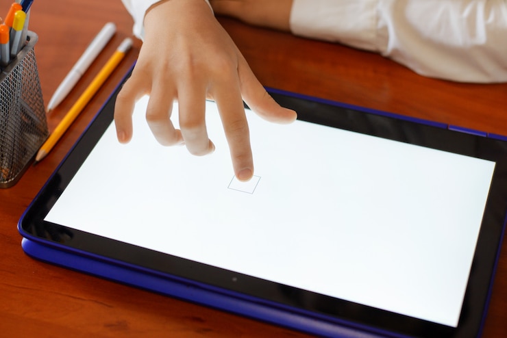Foto niña de la escuela primaria con tableta en el aula