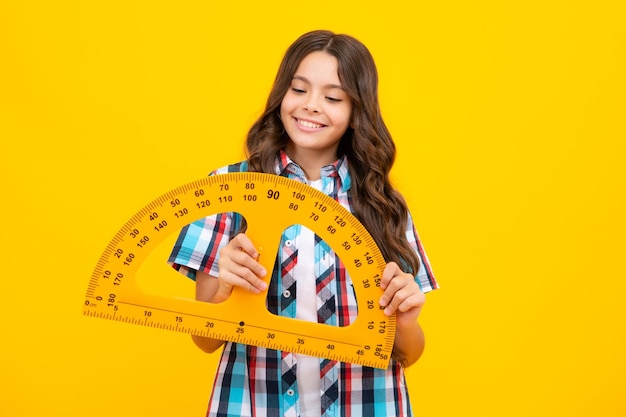 Niña de la escuela sosteniendo la medida para la lección de geometría aislada sobre fondo amarillo Equipo de medición Matemáticas de estudio estudiantil