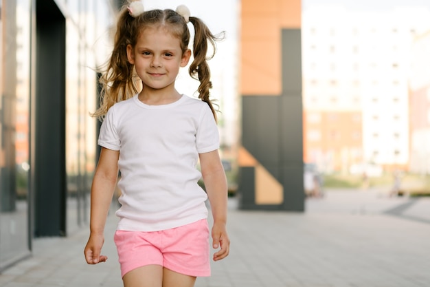 Niña en el espacio de la camiseta blanca para su logotipo o maqueta de diseño para imprimir