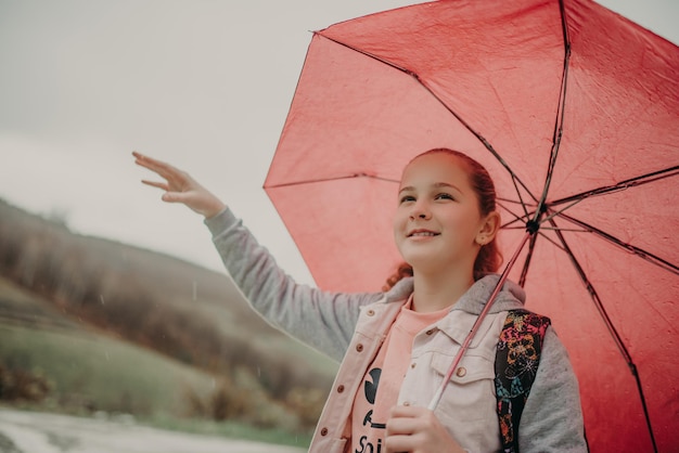 Niña esperando el autobús el día de la lluvia