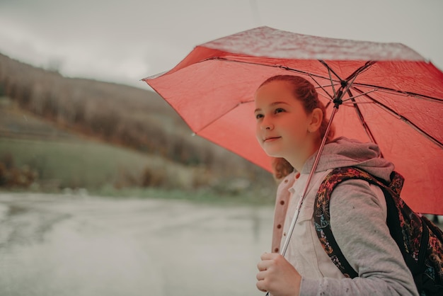 Niña esperando el autobús el día de la lluvia