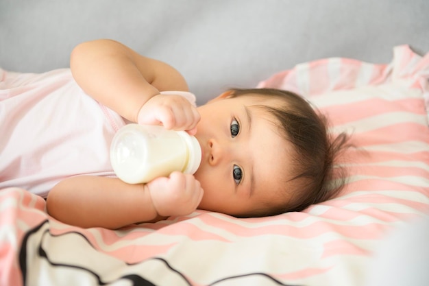 Una niña está bebiendo un biberón de leche concepto de infancia y paternidad infantil familiar