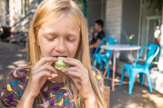 La niña está comiendo macaron