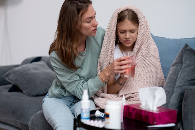 La niña está enferma y su madre la está curando.