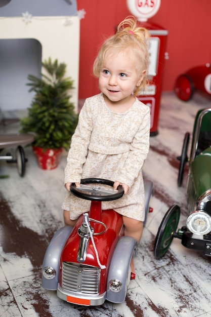 Niña está jugando con coches de juguete.