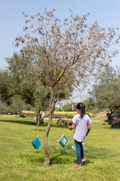 Niña está leyendo un libro bajo el árbol