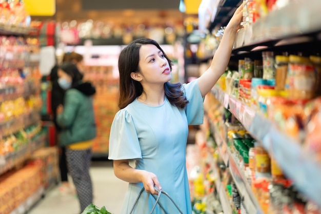 Niña está optando por comprar productos alimenticios en el supermercado