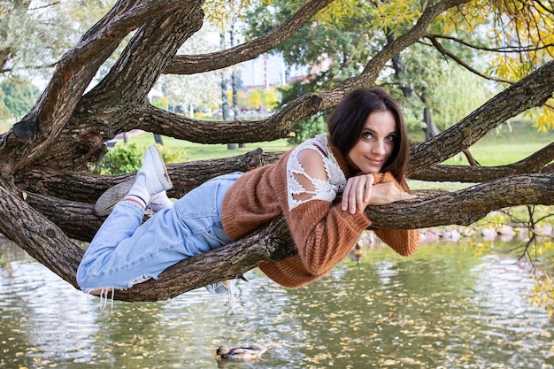 Una niña está punteando en la rama de un árbol.