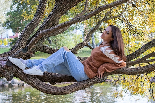 Una niña está punteando en la rama de un árbol.