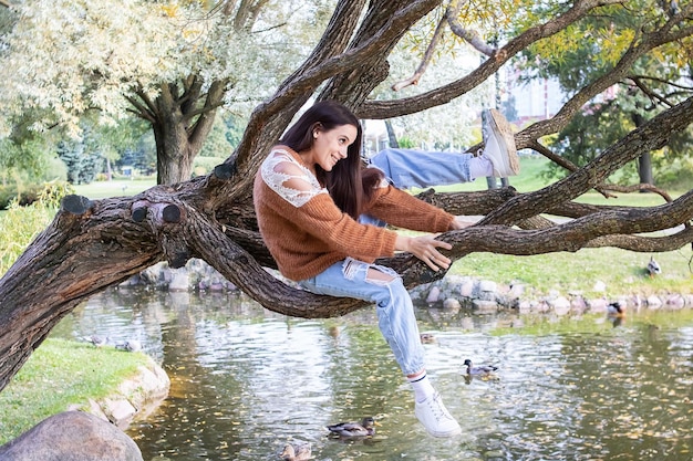 Una niña está punteando en la rama de un árbol.