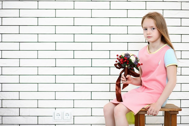 La niña está sentada en una silla