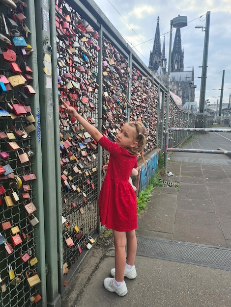 Una niña está subiendo un puente con candados que dicen candados de amor.