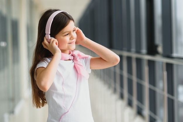 Niña con estilo con auriculares en el aeropuerto