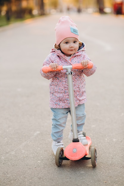 Niña con estilo monta una moto en el parque al atardecer