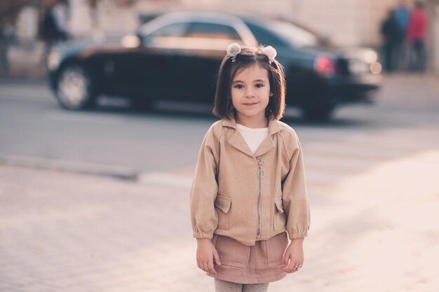 Niña con estilo posando sobre fondo de ciudad