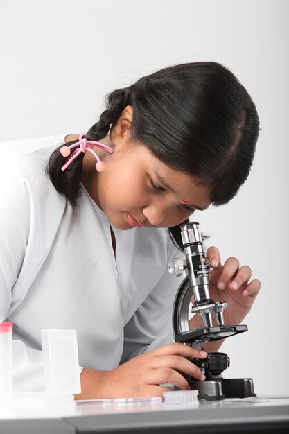 Niña estudiando ciencias contra un fondo blanco